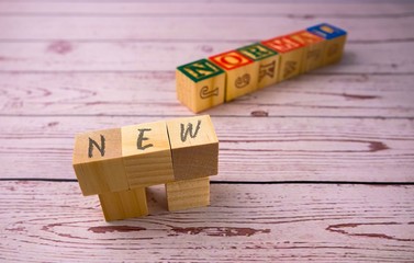 Conceptual of new normal as lifestyle due to Covid-19. Wooden blocks with texts over wooden texture. Selective focus on texts NEW only.