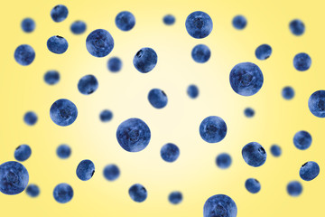 Falling blueberries isolated on a yellow background with clipping path as package design element and advertising. Flying berry.