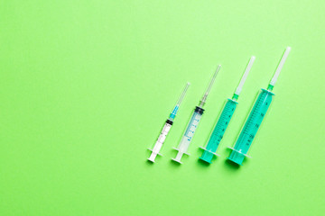 Top view of syringes in a row for medical injection on colorful background with copy space. Health and vaccination concept