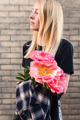 A woman holding cut peonies.