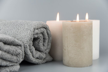 Obraz na płótnie Canvas Towel with aromatic candles. Aromatherapy and beauty. Concept set of harmony, massage, balance and meditation, spa, relax, beauty spa treatment.