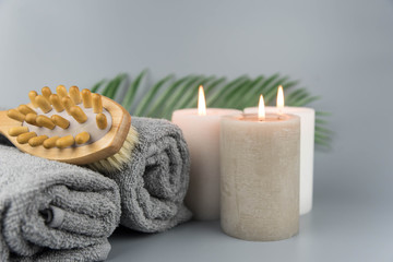 Towel with aromatic candles and massage brush. Aromatherapy and beauty. Concept set of harmony, balance and meditation, spa, relax, beauty spa treatment.