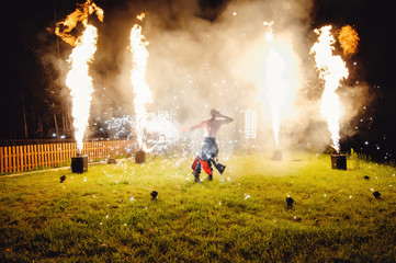 A fire show, dancing with a flame, a masculine master juggling with a firework.  Film noise