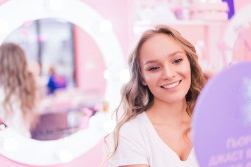 Young woman changing new hair style at the saloon