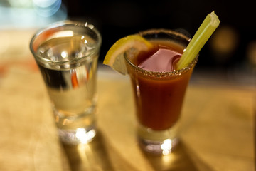 Cocktail in a glass with Tobasco and alcohol. Sambuca. A slice of lemon and celery. The interior of the bar.