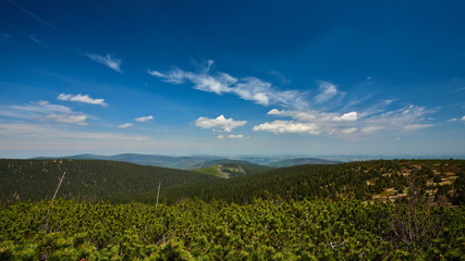 Forested mountainous landscape with clouds on blue sky, Jeseniky mountains, Czech Republic