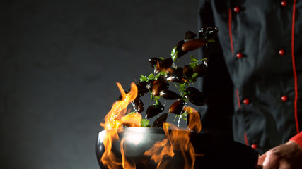 Closeup of chef throwing mussels from wok