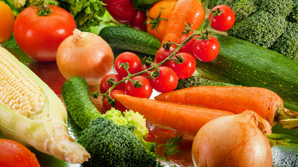 Closeup photo of wet fresh vegetables with water droplets lying on kitchen table