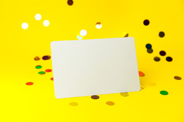 Blank White page mock up and sparkles confetti on Yellow.