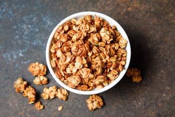 Homemade oatmeal granola bowl on dark background.