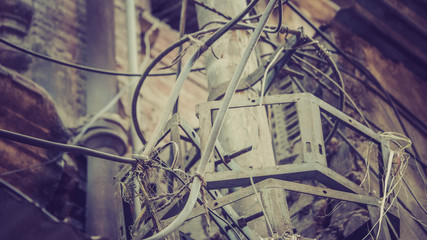 Wires tangled on to the white pole above