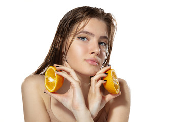 Portrait of beautiful young woman with fresh orange near face over white background. Concept of cosmetics, makeup, natural and eco treatment, skin care. Shiny and healthy skin, fashion, healthcare.