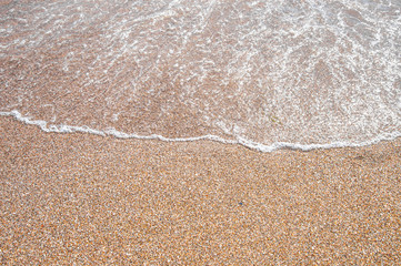 sea wave with foam on the sand