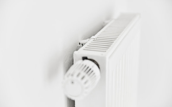 Heizung mit Plattenheizk&ouml;rper und Thermostat an Wand