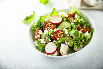 Healthy salad with sun dried tomatoes and fresh cheese