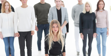 serious woman standing in front of casual group of young people