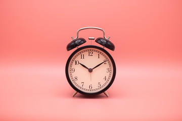 Alarm clock on pink background with copy space for you design.
