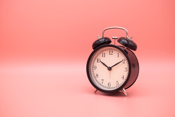 Alarm clock on pink background with copy space for you design.