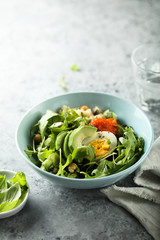 Healthy quinoa bowl with arugula, egg and avocado