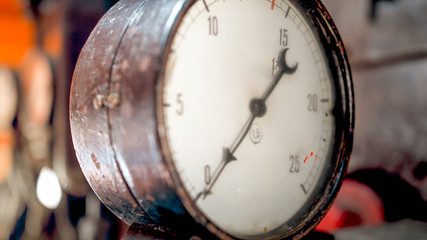 Macro photo of dial and pointer on retro manometer at steam power engine