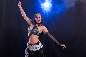 Belly dancer. Young attractive woman dancing tribal fusion on the stage. Oriental exotic dance.