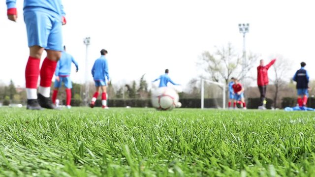 men's soccer team training on the grass field, view out of focus