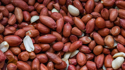Unpeeled Peanuts with brown red shuck. Background. Macro shooting, closeup