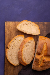 Fresh homemade crisp bread sliced on dark wooden table, top view