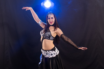 Young woman dancing in Tribal Fusion style. Belly dance on the stage.