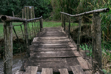 wooden bridge full of dangerous repairs