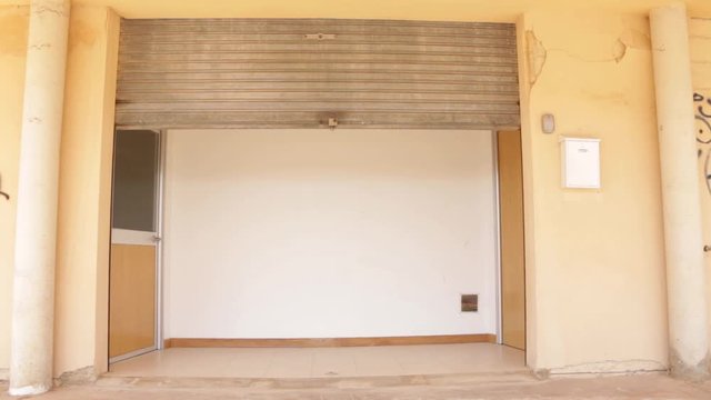 Frontal view of metal shutter of a business closing due to the crisis. Economic recession due to COVID-19