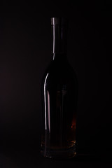 Empty bottle on black background. Bottle silhouette