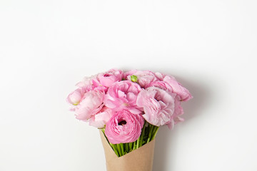 Studio shot of beautiful bouquet of pale pink ranunculus flowers with visible petal texture. Close up composition with bright patterns of flower buds. Top view, isolated, copy space.