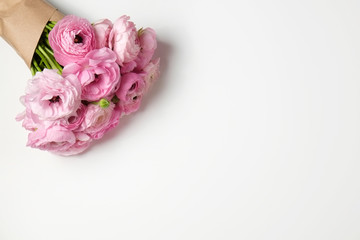 Studio shot of beautiful bouquet of pale pink ranunculus flowers with visible petal texture. Close up composition with bright patterns of flower buds. Top view, isolated, copy space.