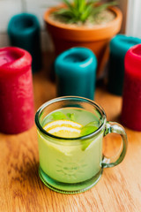 A hot alcoholic drink with mint and lemon in a glass mug