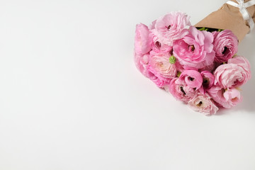 Studio shot of beautiful bouquet of pale pink ranunculus flowers with visible petal texture. Close up composition with bright patterns of flower buds. Top view, isolated, copy space.