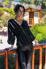 beautiful thin girl in a black Japanese suit and glasses in a Japanese garden