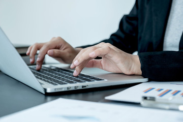 Fototapeta na wymiar business female is sitting at a desk and calculating financial graph that show results