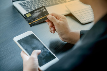 Office girl who hold credit cards and smartphones for online shopping and making payments online