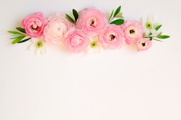 Studio shot of beautiful bouquet of pale pink ranunculus flowers with visible petal texture. Close up composition with bright patterns of flower buds. Top view, isolated, copy space.