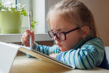 Little girl with tablet and stylus learning drawing online