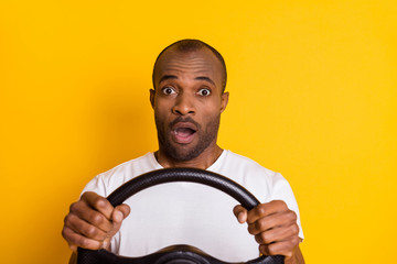 Portrait of astonished afro american driver hold steering wheel impressed big city traffic jam...