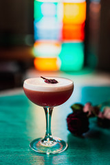 A classic sour cocktail in coupe glass with hibiscus