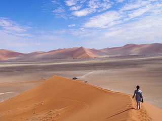 A woman barefoot down a beautiful sand Dune 45, Namibia