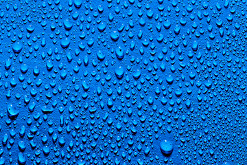 Macro water drops texture on a blue backdrop. Abstract pattern or blank for design.
