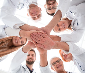 Fototapeta na wymiar close up. group of different doctors putting their hands together