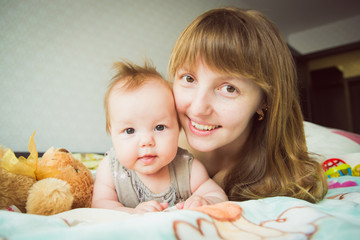 Young mother with her little baby. Loving mother takes care of her daughter