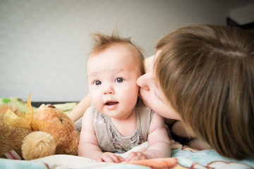 Young mother with her little baby. Loving mother takes care of her daughter