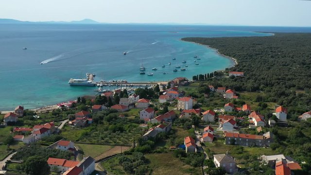 Olib Island, Croatia - Coral Reef Under The Clear Blue Sea With Lush Trees, Hotels And Apartments For Tourists - aerial shot