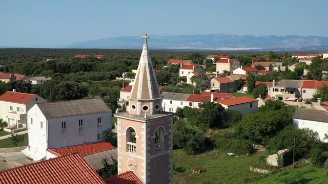 The Tower Of Parish Church Assumption Of Mary In The Village Of Olib In Croatia - aerial circling shot